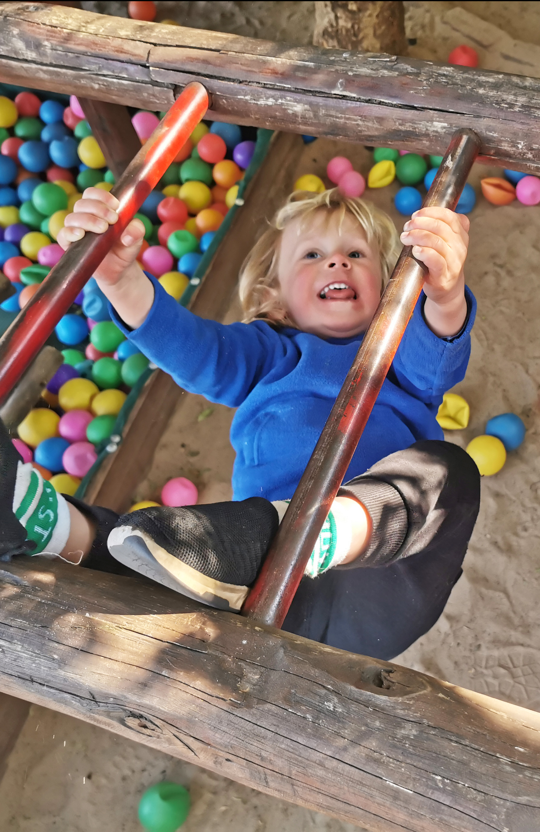 Boy hanging on monkey bars